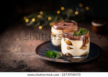 Traditional Italian dessert tiramisu in a glass on on dark background Royalty-Free Stock Photo #1873958470