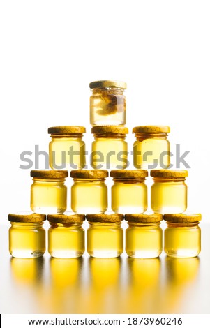 Vertical photo of a pyramid made from some jars full of honey.