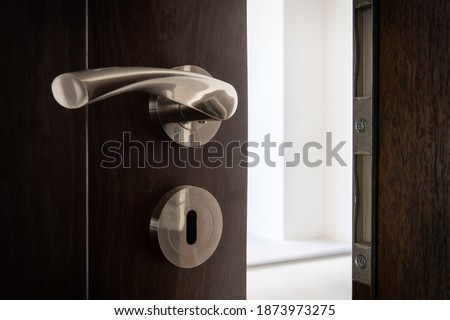 Slightly opened door to a ampty room. Door handle, door lock. Welcome, to new home concept