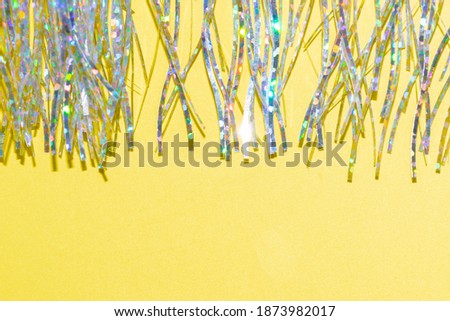 silver holographic tinsel fringe on an illuminating yellow background with trendy colors Royalty-Free Stock Photo #1873982017