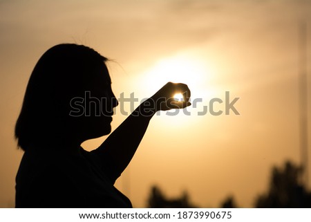 Girl holding a gloss, frontal light, background focus. 