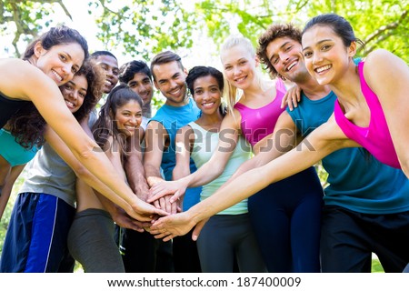 Group of friends putting their hands together in the park Royalty-Free Stock Photo #187400009