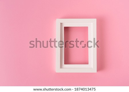 Minimalistic style. Picture frame on pink paper background.
