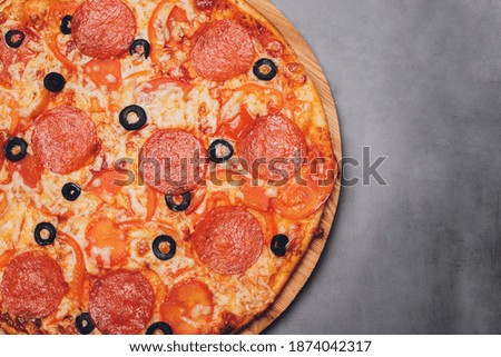Pizza pepperoni, mozzarella, oregano on a black background.