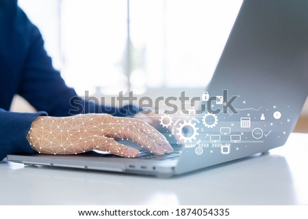 close up on robot (ai) hand working on laptop to checking correct data by use RPA function software program to help proof and detect and synchronize to system for future technology of business concept Royalty-Free Stock Photo #1874054335