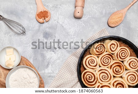 Raw cinnabon buns with cinnamon on ultimate grey backdrop. Ingredients and recipe. Christmas bakery. Flatlay. Kitchen appliances. 