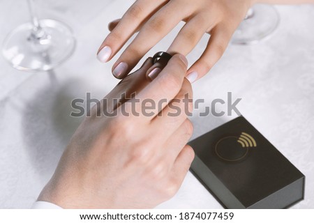 A man gives a woman a smart payment ring. Romantic dinner. Valentine's Day