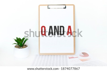 Top view notebook, pen and plant potted on white wood desk background. Lifestyle, business finance, education technology concept. Copy space. Text Q AND A