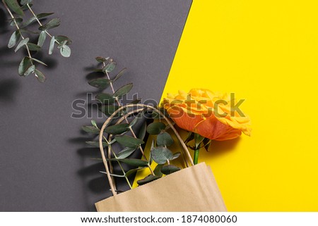 Fresh aromatic flowers in reusable paper bag on trendy two tone background with copy space for your design. Flowers delivery banner. Eco shopping concept.
