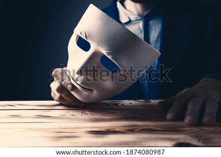 Businessman holding white mask in his hand Royalty-Free Stock Photo #1874080987