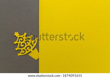 Postcard with paper cut Christmas tree on grey yellow background. Trendy color of the year 2021 yellow and gray