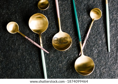 Set of stylish and colorful spoons isolated on a black background. Flat and top view
