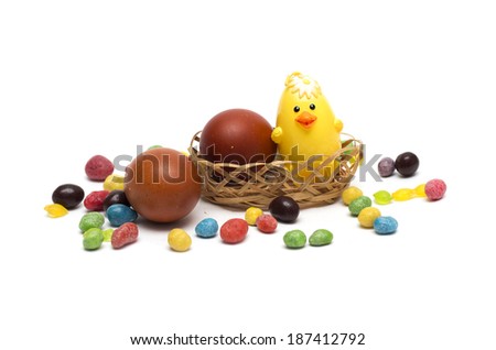 Happy Easter. Chicken with Easter eggs and colored candies. Photo.