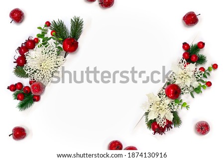 Christmas decoration. Frame of white openwork flowers poinsettia, branch christmas tree, red berries, apples and white paper card note with space for text on white background. Top view, flat lay