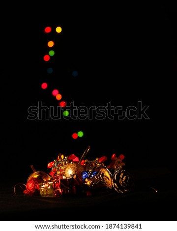 Colorful Christmas decorations and colorful bokehs in the background. In black background.