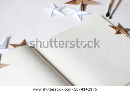 Creative Design Mock-up with Open Notebook and Paper Stars. Minimal Christmas Background with Copy Space.
