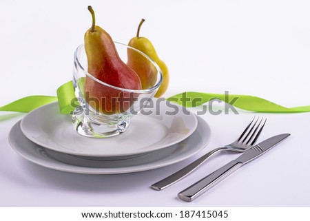 Pears, bowl, plates and silverware on the table as background for invitation