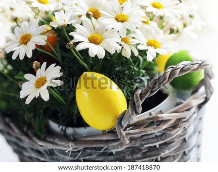 Photo of basket with daisy flowers and easter eggs