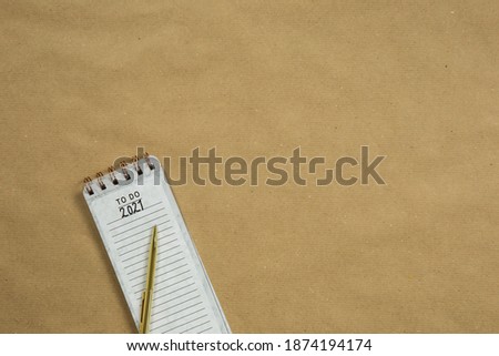 Planning New Year goald on empty notepad in the year 2021, top view on brown background texture, top view copy space, space for text modern design close-up