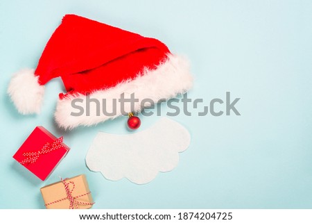 Creative christmas composition with Santa and presents. Flat lay image on blue background.