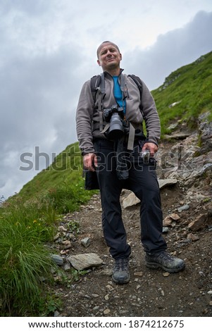 Man hiker taking pictures of mountain landscape