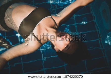 Fashion portrait of graceful cute girl in stylish sunglasses posing in the pool during holidays on luxury resort. Cheerful plus size teenage girl enjoying. happy, positive emotion, summer style.