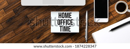 lightbox with message HOME OFFICE TIME surrounded by office items on wooden background