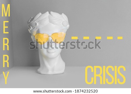 White sculpture of an antique head in pink glasses with hearts. On a geometric background yellow and gray color