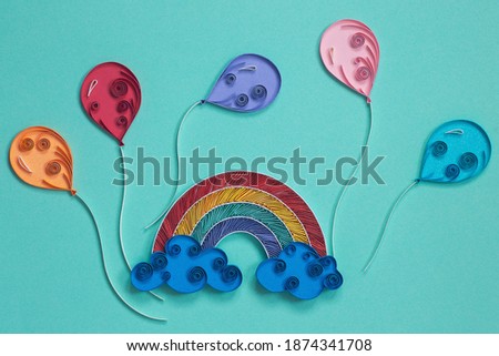 The rainbow with clouds and colorful balloons on blue background . Party elements. Hand made of paper quilling technique.