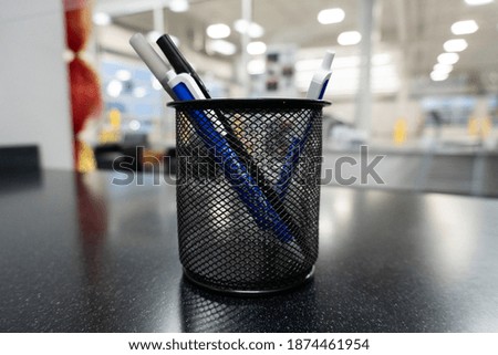 cup of pens on a countertop