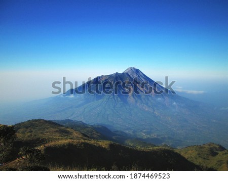 Gunung Merbabu adalah salah satu gunung api tipe Strato di Jawa Tengah, Indonesia. Memiliki tinggi 3.145 meter di atas permukaan laut. Secara geografis terletak pada 7,5° LS dan 110,4° BT. Royalty-Free Stock Photo #1874469523