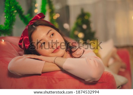 Beauty young asian woman black hair with red ribbon headband laying on a couch.