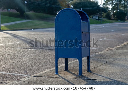 Lone city postal mailbox on the side of a street