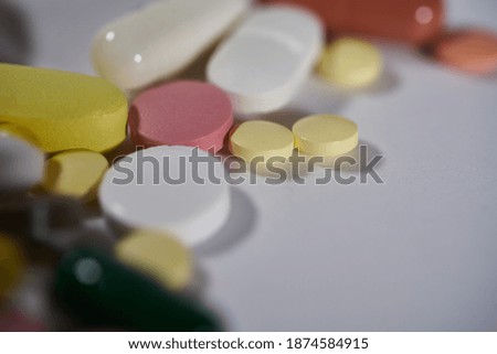 Colored pills, tablets and capsules on a white background. macro photography