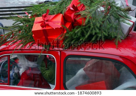 In a red retro car Sanata carries gifts to children                               