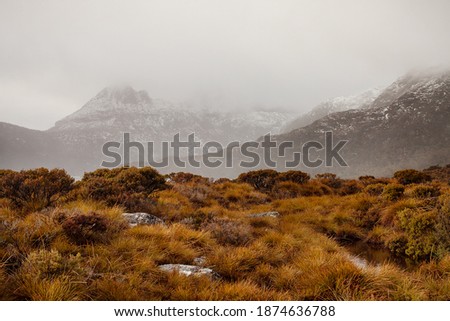 View of snow capped Cradle Mountain across Dove Lake on a cold misty morning, located within the Cradle Mountain-Lake St Clair National Park