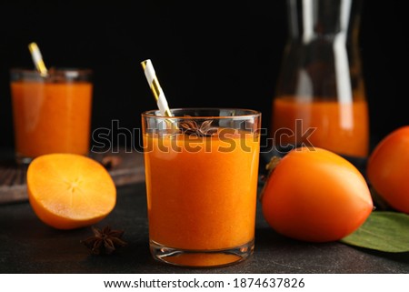 Tasty persimmon smoothie with anise and fresh fruits on black table
