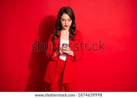 Photo of charming young girl hold cellphone look screen serious face wear blazer isolated red color background