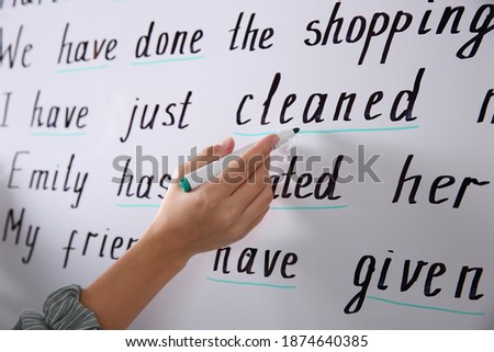 English teacher underlining word on whiteboard at lesson, closeup Royalty-Free Stock Photo #1874640385