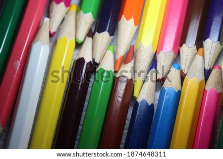 Close-up view of bright colored multicolor pencils on black background
