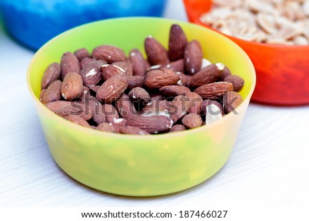 Almonds and other dried fruits and cookies in colored bowls