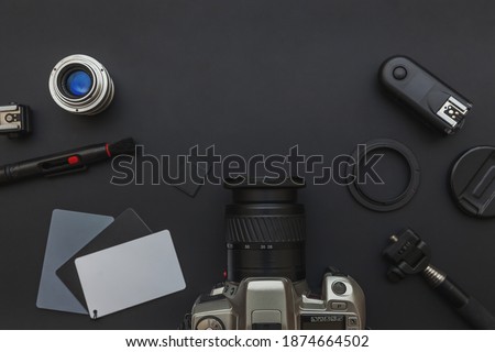 Photographer work place work space with dslr camera system, camera cleaning kit, lens and camera accessory on dark black background. Hobby travel photography concept. Flat lay top view copy space