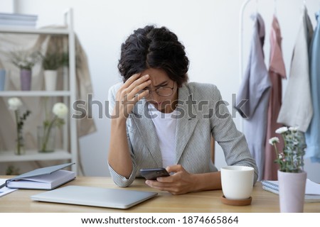 Unexpected problems. Concerned young woman self employed florist getting email with bad news about debt bankruptcy. Female tailor owner of make and mend service stressed after losing customer order Royalty-Free Stock Photo #1874665864