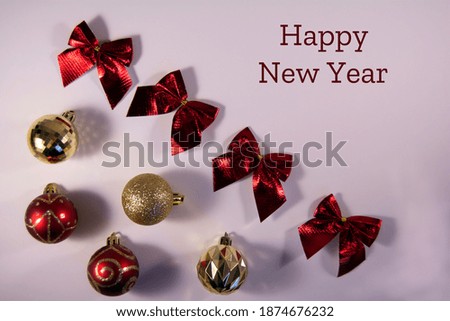 Frame christmas decoration with golden and red balls and red bow on a white background with inscription. Holiday concept. Flat lay and top view
