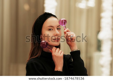 Woman massaging her face with Facial Ice Globes. High quality photo
