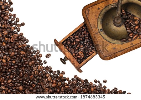 Old vintage manual coffee grinder with roasted coffee beans, isolated on white background. Top view.