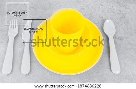 picnic illuminating yellow cutlery utensils, plates, cups, fork, spoon and knife on trendy ultimate grey background. Eco friendly plastic. Selective focus