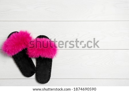 Pair of soft slippers on white wooden background, flat lay. Space for text
