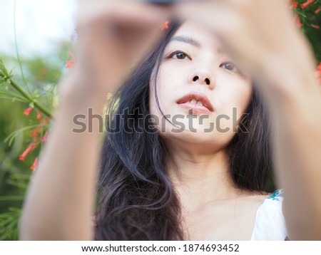 Self portrait of beautiful young asian woman smiling on nature and sky background in the park. Travel. Selfie. Instagram