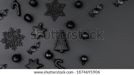 Christmas minimalistic and simple composition in mat black color. Christmas gifts, decorations on black background. Flat lay, top view with copy space